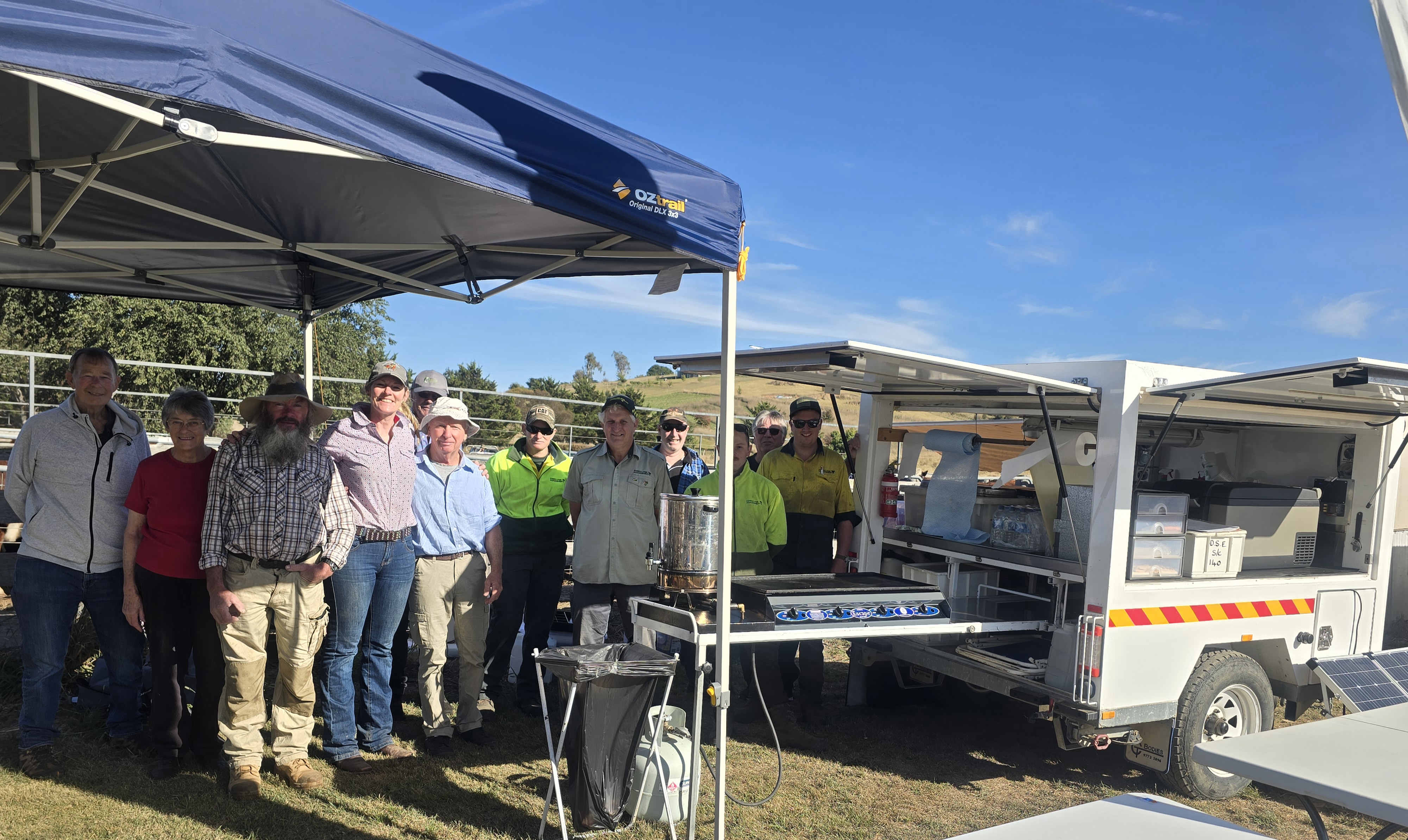 volunteers at an event posing next to an emergency services catering truck